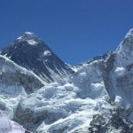 The world's highest peak, Mount Everest, is seen from a distance on a bright sunny day.