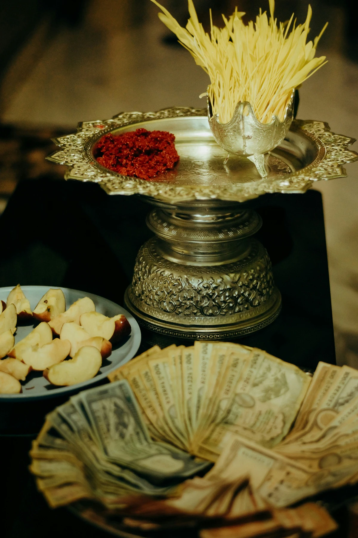 Traditional offerings during the Dashain festival in Nepal, including jamara (barley sprouts), red tika, sliced fruits, and neatly arranged Nepali currency placed on ornate metal trays—highlighting the spiritual and festive significance of Cultural tourism in Nepal.