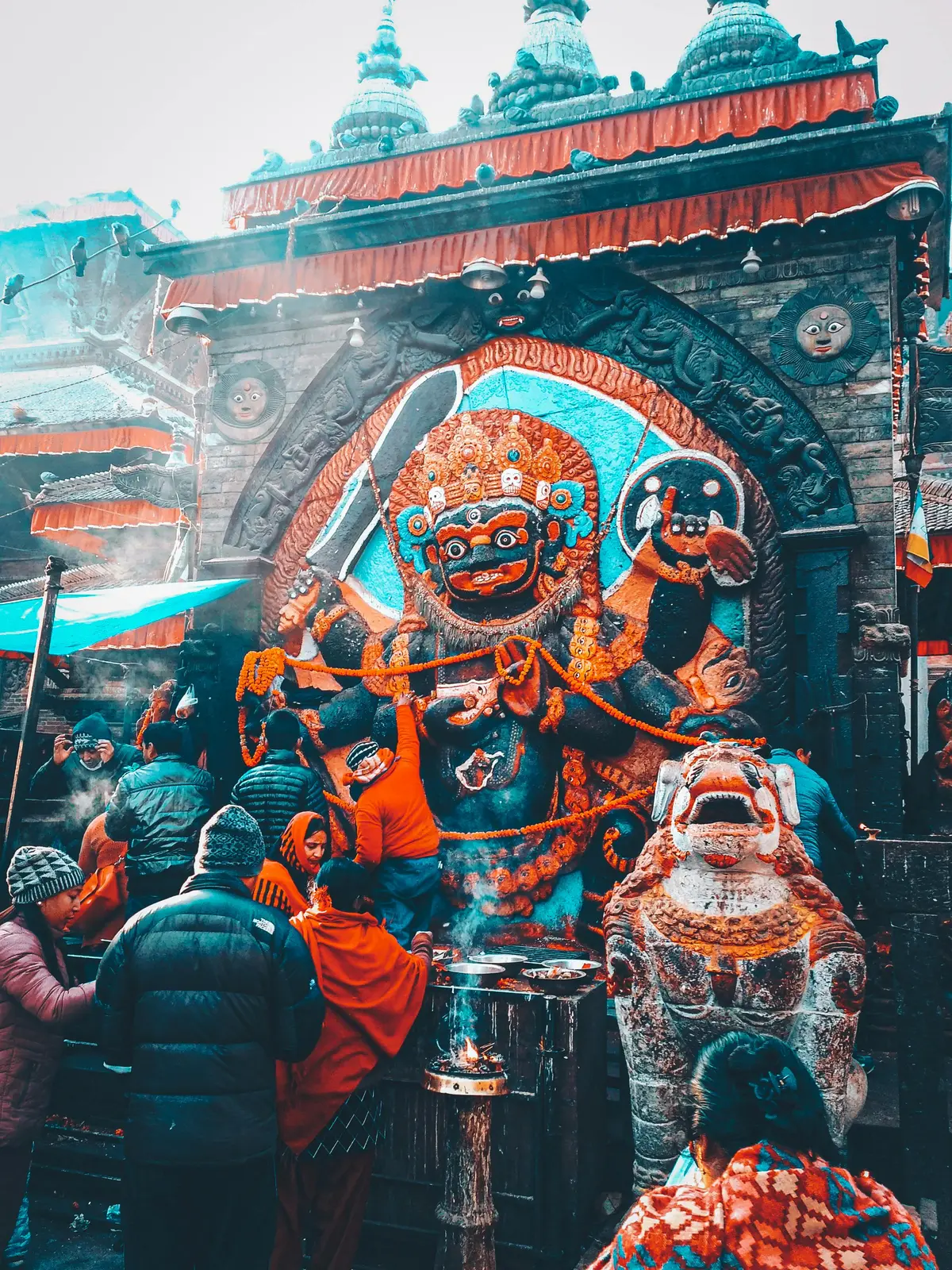 Devotees offering prayers at the fierce statue of Kal Bhairav, a significant deity among Kathmandu Valley temples, located in the historic Durbar Square of Kathmandu, Nepal.