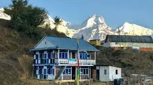 a house with a mountain in the background seen during Nagthali Trek in Rasuwa district