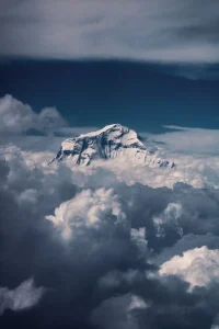 Snow-covered Dhaulagiri rising above dramatic clouds during the Dhaulagiri Circuit Trek, showcasing one of Nepal's most remote and spectacular Himalayan landscapes.