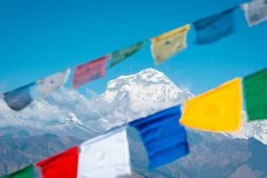 Colorful prayer flags framing the majestic Dhaulagiri peak along the Dhaulagiri Circuit Trek, showcasing Nepal's breathtaking Himalayan scenery.